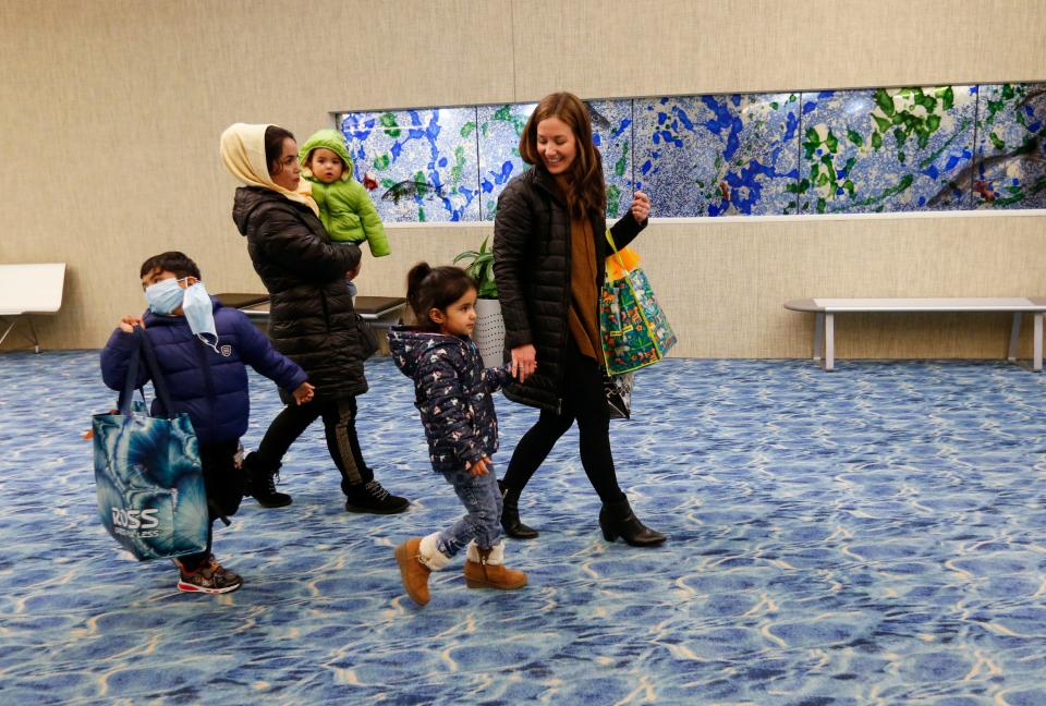 Farishta Noori holds 10-month-old Sorosh Noori while Sally Breedlove holds the hand of 5-year-old Behishta Noori and 6-year-old Abdul Bai Noori walks alongside as they make their way to baggage claim at the Springfield-Branson National Airport on Monday, Jan. 10, 2022. The Nooris fled Afghanistan after the troop withdrawal last year.