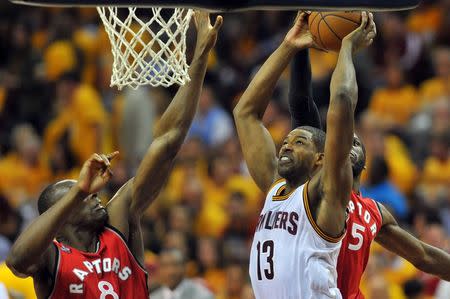 May 19, 2016; Cleveland, OH, USA; Cleveland Cavaliers center Tristan Thompson (13) shoots the ball as Toronto Raptors center Bismack Biyombo (8) and forward DeMarre Carroll (5) defend during the second half in game two of the Eastern conference finals of the NBA Playoffs at Quicken Loans Arena. The Cavaliers won 108-89. Mandatory Credit: Ken Blaze-USA TODAY Sports