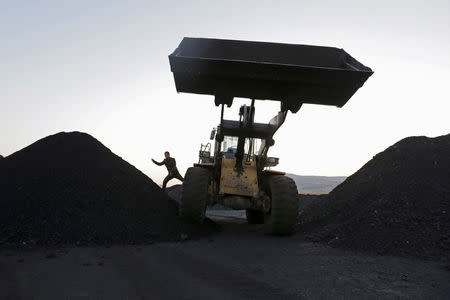 FILE PHOTO: A driver gets off a loading vehicle at local businessman Sun Meng's small coal depot near a coal mine of the state-owned Longmay Group on the outskirts of Jixi, in Heilongjiang province, China, October 23, 2015. REUTERS/Jason Lee/File Photo