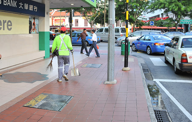 A worker walks on a sidewalk in Singapore. (Yahoo! photo)