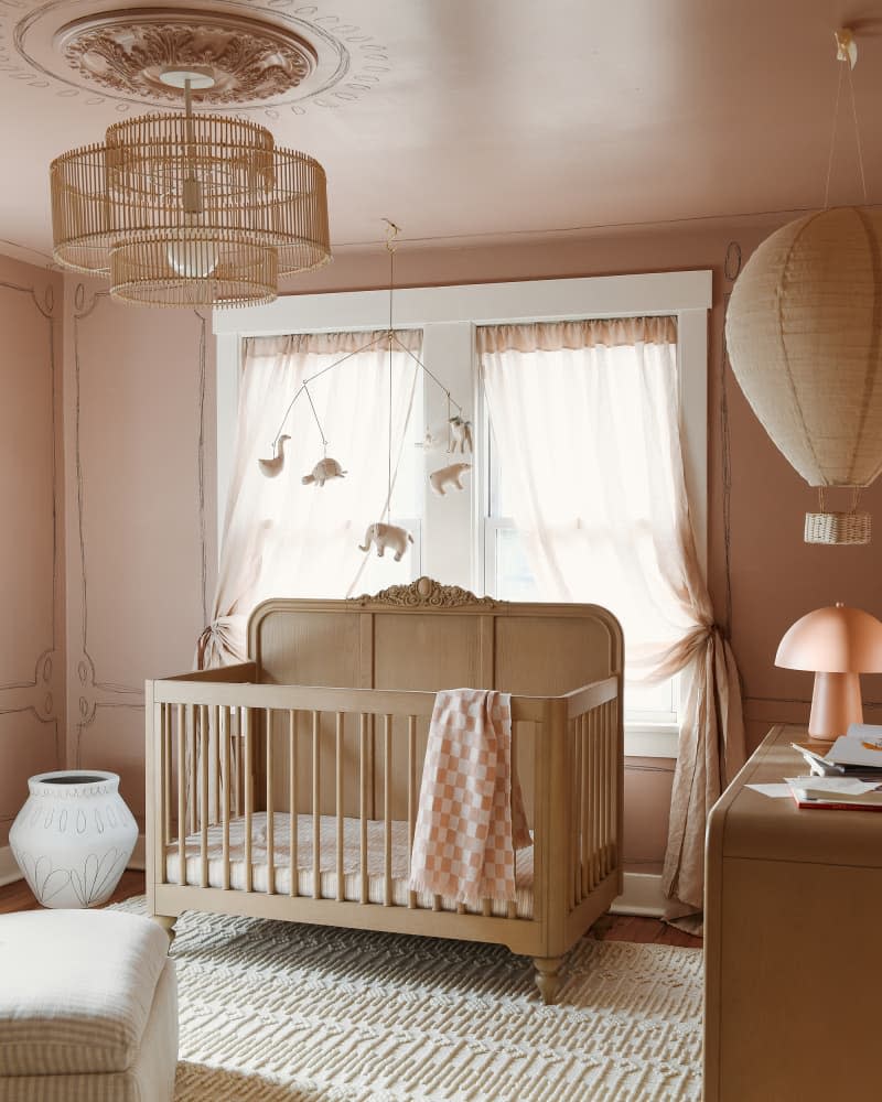 Mobile over wooden crib in newly designed nursery.