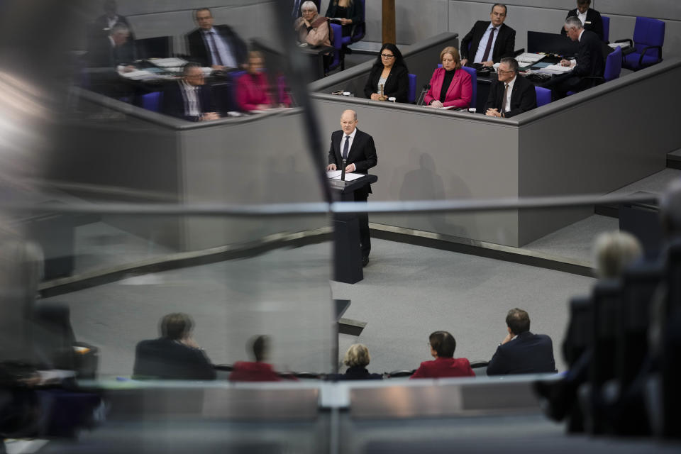 German Chancellor Olaf Scholz, center, delivers a speech about Germany's budget crisis at the parliament Bundestag in Berlin, Germany, Tuesday, Nov. 28, 2023. With its economy already struggling, Germany now is wrestling to find a way out of a budget crisis after a court struck down billions in funding for clean energy projects and help for people facing high energy bills because of Russia's war in Ukraine. (AP Photo/Markus Schreiber)