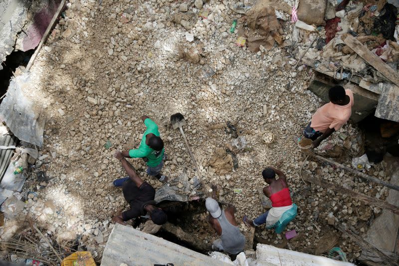 People work in an area affected by the passage of Tropical Storm Laura, in Port-au-Prince