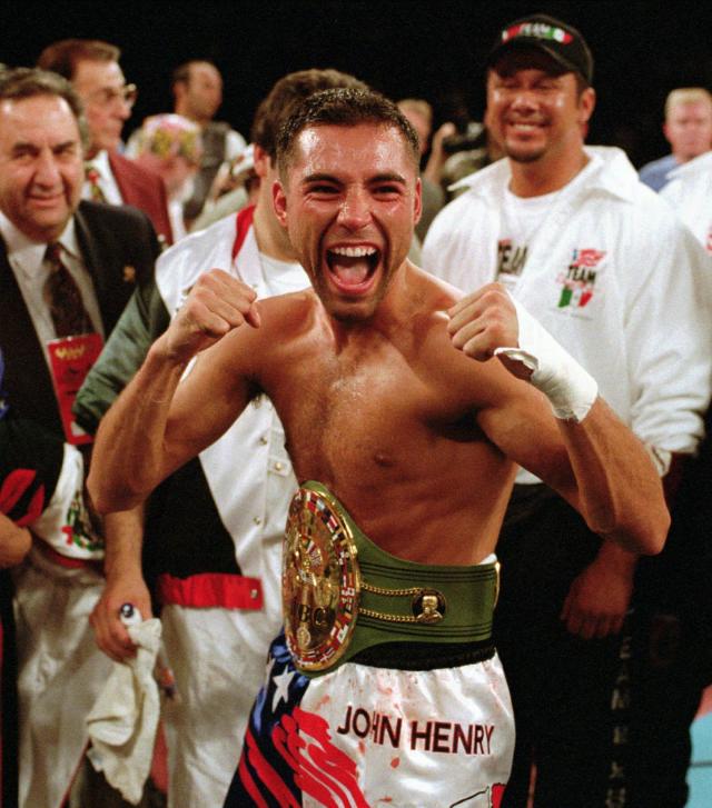 FILE - Newly crowned WBC super lightweight champion Oscar De La Hoya poses with the belt he won from Julio Cesar Chavez in Las Vegas on June 7, 1996. A new film, “La Guerra Civil,” by Eva Longoria Bastón, examines the cultural divide the fight illuminated for many Mexican-Americans. The documentary premiered Thursday night at the Sundance Film Festival. (AP Photo/Lennox McLendon, File)