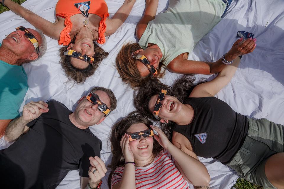 Bernie Kaplan, left teal, Debbie Schwartz, orange, Scott Wechsler, black, Adrya Koenig, striped, Stacey Alpert, light green, all of Boca Raton and Lindsey Chervitz, black, Austin, Texas, watch the solar eclipse at a viewing event at Florida Atlantic University on April 8, 2024, in Boca Raton.