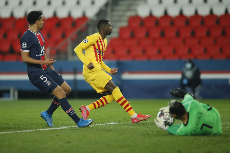 PSG's goalkeeper Keylor Navas, right, makes a save in front Barcelona's Ousmane Dembele during the Champions League, round of 16, second leg soccer match between Paris Saint-Germain and FC Barcelona at the Parc des Princes stadium in Paris, Wednesday, March 10, 2021. (AP Photo/Christophe Ena)