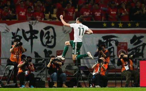 Gareth Bale is cheered by the fans in China - Credit: GETTY IMAGES