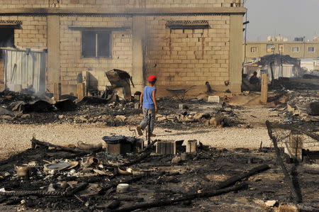 A boy walks near the remains of tents that were burnt in a refugee camp for Syrian refugees in Lebanon's Bekaa Valley June 1, 2015. REUTERS/Hassan Abdallah