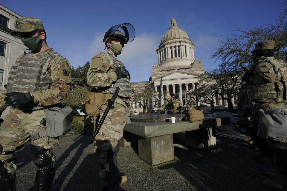 Members of the Washington National Guard stand at a sundial near the Legislative Building, Sunday, Jan. 10, 2021, at the Capitol in Olympia, Wash. Governors in some states have called out the National Guard, declared states of emergency and closed their capitols over concerns about potentially violent protests. Though details remain murky, demonstrations are expected at state capitols beginning Sunday and leading up to President-elect Joe Biden's inauguration on Wednesday. (AP Photo/Ted S. Warren)