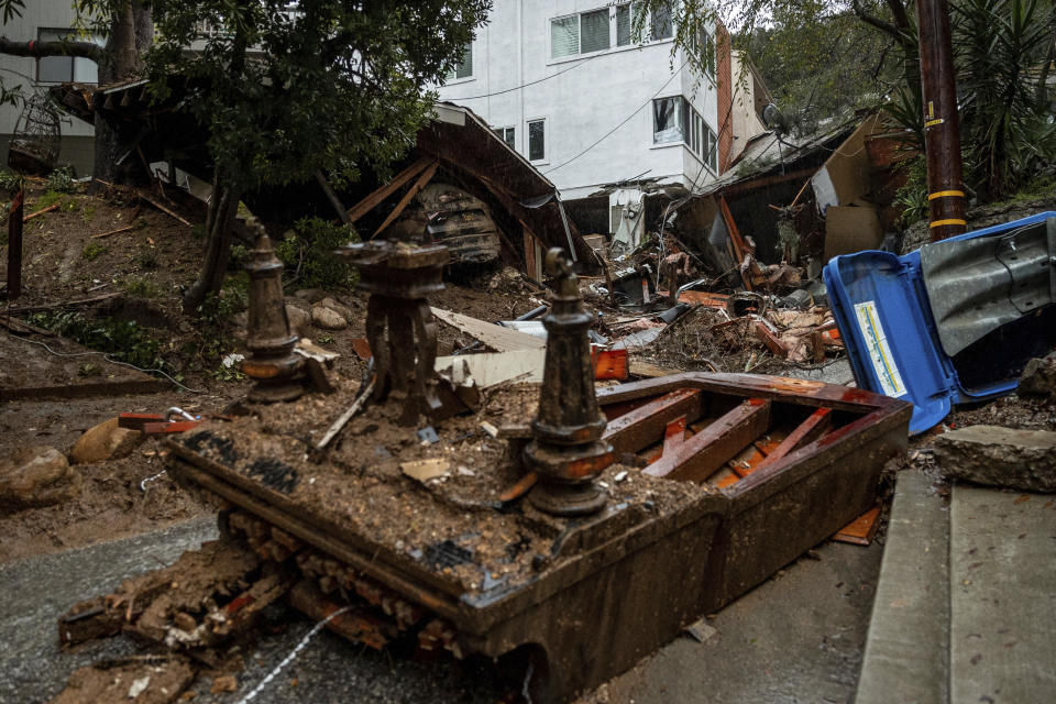 A grand piano lays upside down at a property destroyed by a mudslide during a storm, Tuesday, Feb. 6, 2024, in the Beverly Glen area of Los Angeles. (AP Photo/Ethan Swope)