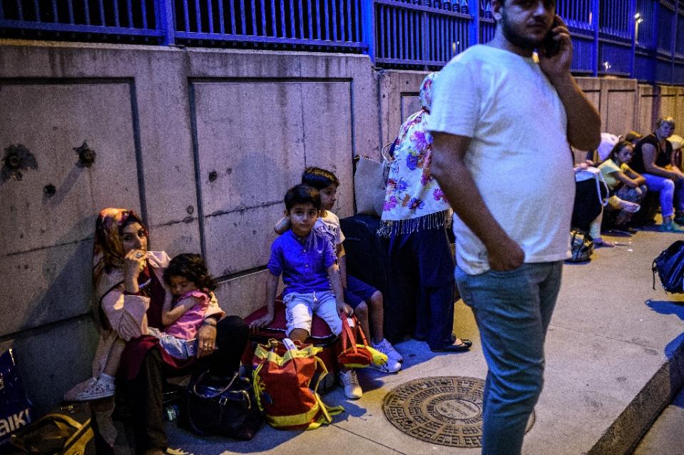 Varias personas esperan en el exterior de la terminal (Reuters).