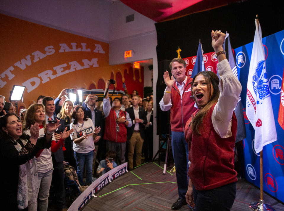 Yesli Vega, right, and Gov. Glenn Youngkin cheer with the crowd during a rally at Gourmeltz in Spotsylvania County, Va., Monday, Oct. 17, 2022. (Tristan Lorei/The Free Lance-Star via AP)