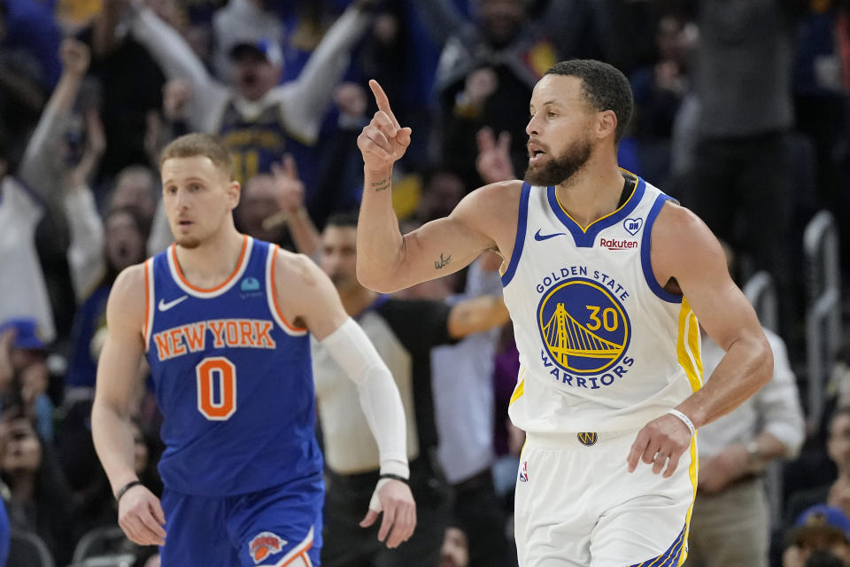 Golden State Warriors guard Stephen Curry (30) gestures after making a 3-point basket in front of New York Knicks guard Donte DiVincenzo (0) during the first half of an NBA basketball game in San Francisco, Monday, March 18, 2024. (AP Photo/Jeff Chiu)