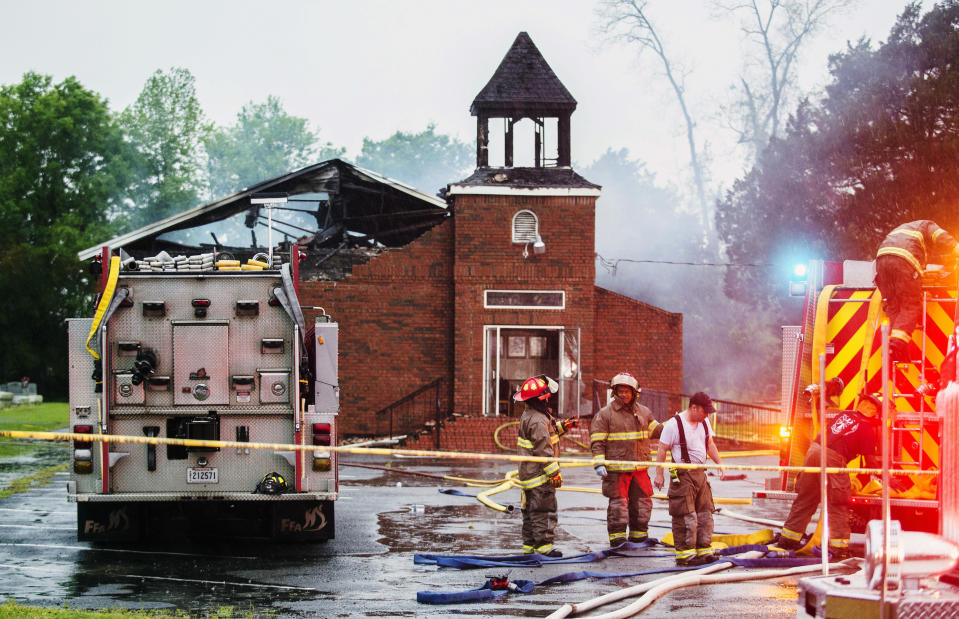 FILE - In this April 4, 2019, file photo, firefighters and fire investigators respond to a fire at Mount Pleasant Baptist Church, in Opelousas, La. Vice President Mike Pence is coming to Louisiana to show his support for members of three black churches, including Mount Pleasant, burned by an arsonist. (Leslie Westbrook/The Advocate via AP, File)