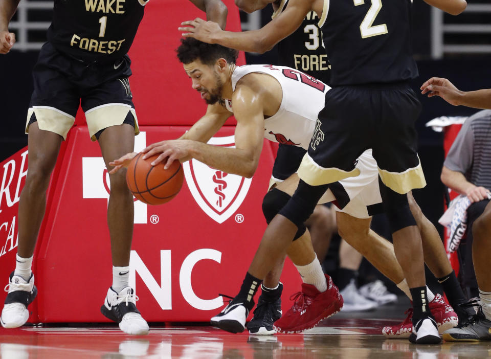 North Carolina State's Devon Daniels (24) escapes the pressure from Wake Forest defenders during the first half of an NCAA college basketball game Wednesday, Jan. 27, 2021, in Raleigh, N.C. (Ethan Hyman/The News & Observer via AP, Pool)