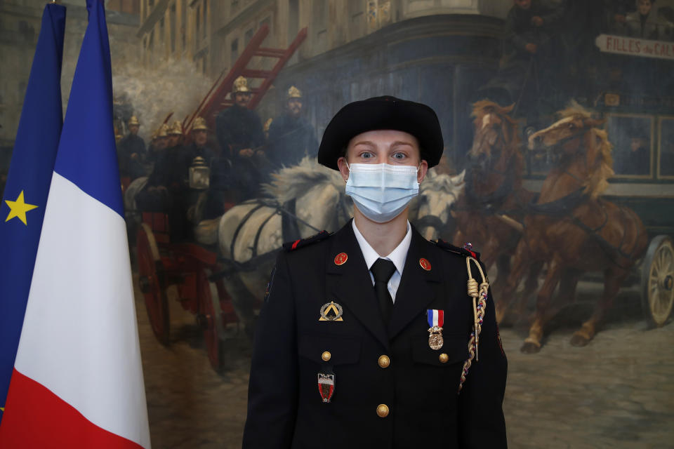 French math teacher-volunteer fighter, Marion Dehecq, poses after she receives a bronze medal for courage and dedication as she used CPR to save the life of a jogger, during a ceremony with France's minister for citizenship issues, Marlene Schiappa at the Paris fire service headquarters in Paris, France, Monday, May 10, 2021. The jogger's wife, Paris-based Associated Press journalist Lori Hinnant, helped identify the anonymous rescuer by putting up thank-you signs in Monceau Park, where her husband Peter Sigal went into cardiac arrest on April 28. (AP Photo/Francois Mori, pool)