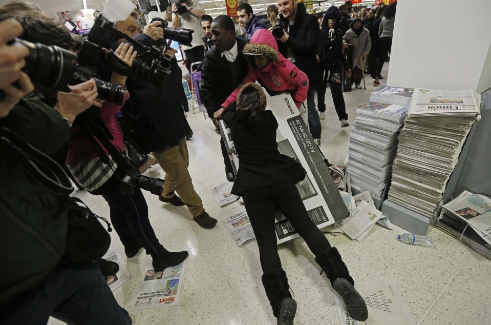 Shoppers wrestle over a television as they compete to purchase retail items on "Black Friday" at an Asda superstore in Wembley