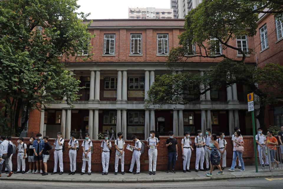 Students wearing mask stand around King's College in Hong Kong, Monday, Sept. 9, 2019. Thousands of demonstrators in Hong Kong urged President Donald Trump to "liberate" the semiautonomous Chinese territory during a peaceful march to the U.S. Consulate on Sunday, but violence broke out later in the business and retail district as police fired tear gas after protesters vandalized subway stations, set fires and blocked traffic. (AP Photo/Kin Cheung)