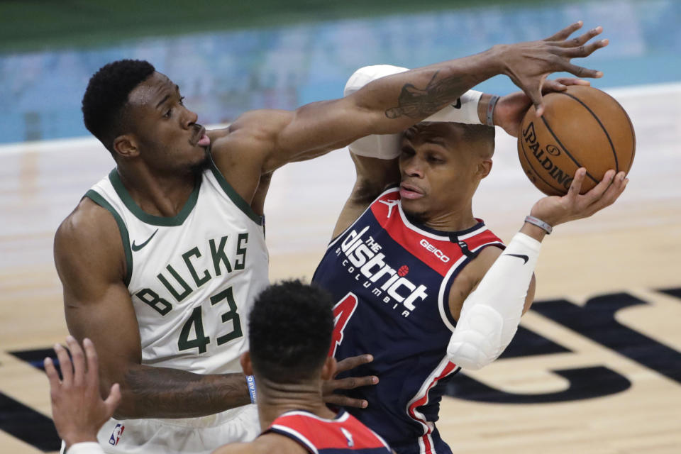 Washington Wizards' Russell Westbrook, right, looks to pass around Milwaukee Bucks' Thanasis Antetokounmpo (43) during the first half of an NBA basketball game Wednesday, May 5, 2021, in Milwaukee. (AP Photo/Aaron Gash)