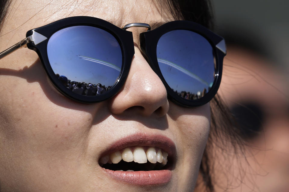 In this Wednesday, Nov. 7, 2018, file photo, a visitor wearing sunglasses with the reflection of the China's K-8 aircrafts from the Aerobatic Team "Hongying", meaning Red Eagle, of Chinese PLA's (People's Liberation Army) Air Force during performance at the 12th China International Aviation and Aerospace Exhibition in Zhuhai city, south China's Guangdong province. (AP Photo/Kin Cheung, File)