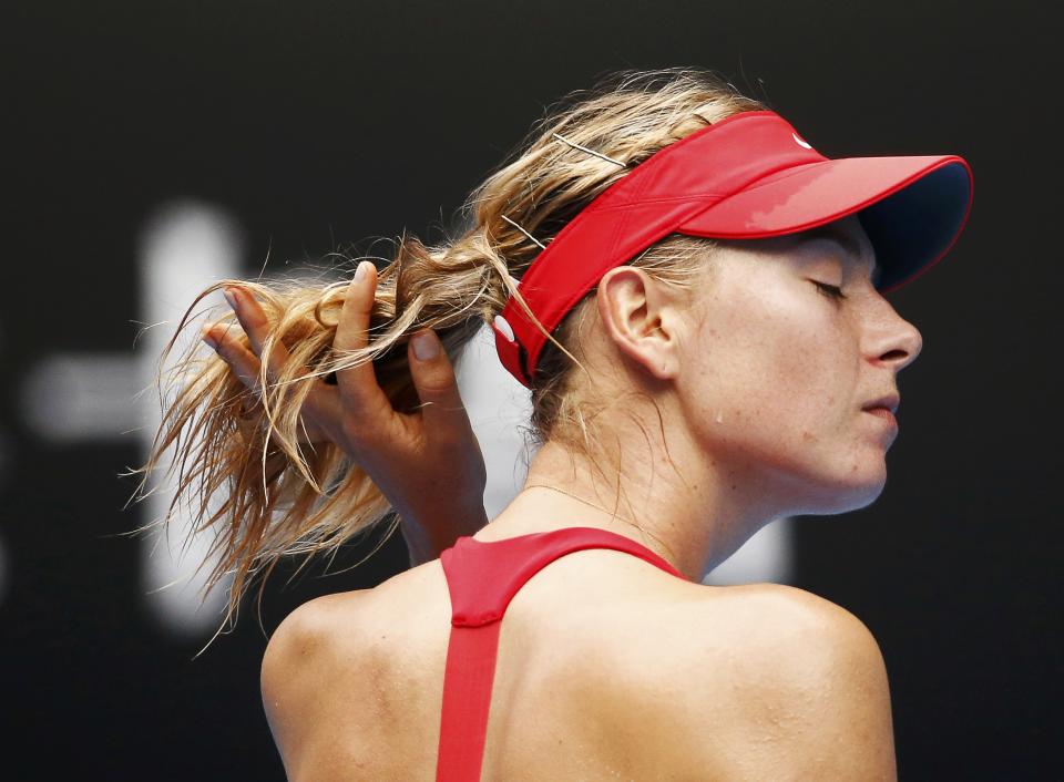 Maria Sharapova of Russia reacts after missing a shot to compatriot Alexandra Panova during their women's singles second round match at the Australian Open 2015 tennis tournament in Melbourne January 21, 2015. Sharapova defeated Panova to win the match. REUTERS/Thomas Peter (AUSTRALIA - Tags: SPORT TENNIS)