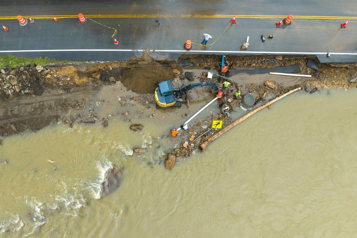 Volunteers and city workers try to reconnect the water supply to a nursing home in Elkhorn City, Ky., on Friday, July 29, 2022. The pipe, along with some of KY-197, washed away yesterday when the Russel Fork flooded.