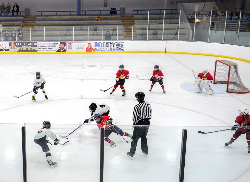 FILE - Players on the Minneapolis, wearing white and black uniforms, and Orono, wearing red uniforms, teams compete in a 10-and-under youth hockey game Feb. 4, 2024, in Minneapolis. While Canada has seen a steep decline in children playing hockey in the sport's birthplace, the United States has experienced steady growth in that department over the past decade. (AP Photo/Abbie Parr, File)