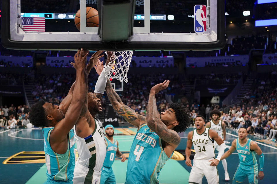 Milwaukee Bucks guard Damian Lillard shoots between Charlotte Hornets guard Ish Smith, left, and center Nick Richards during the first half of an NBA basketball game on Friday, Nov. 17, 2023, in Charlotte, N.C. (AP Photo/Chris Carlson)