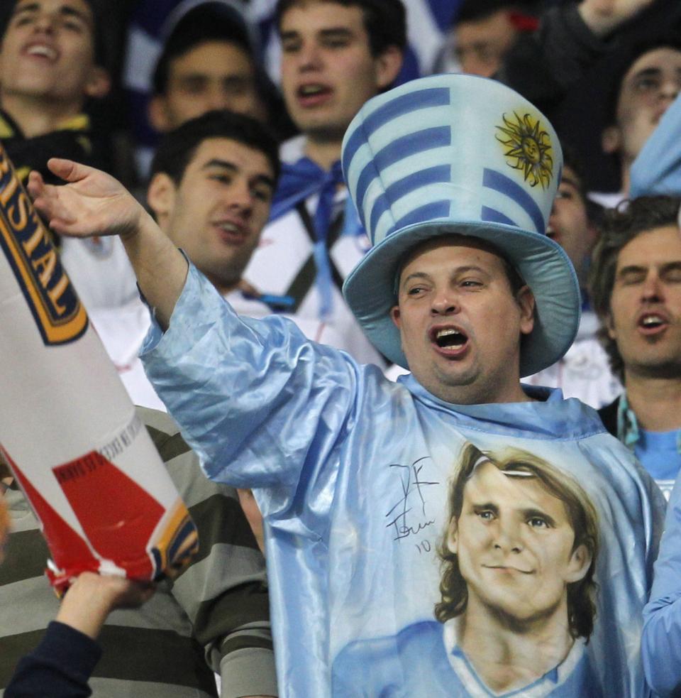 A Uruguay fan wearing a shirt with the image of of striker Diego Forlan, cheers during their 2014 World Cup qualifying soccer match against Peru in Lima