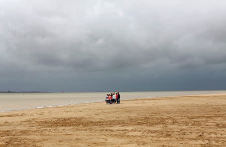 A group of people stand on the beach in Donana National Park, southern Spain, May 11, 2016. REUTERS/Marcelo del Pozo/File Photo