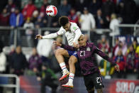 United States' Antonee Robinson, left, goes up for the ball against Mexico's Luis Rodriguez during the first half of a FIFA World Cup qualifying soccer match, Friday, Nov. 12, 2021, in Cincinnati. (AP Photo/Julio Cortez)