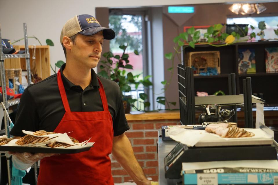 Owner Jason Isbanoly carries a tray at Noble Meats, 2469 Lillington Highway (Route 210), Spring Lake.