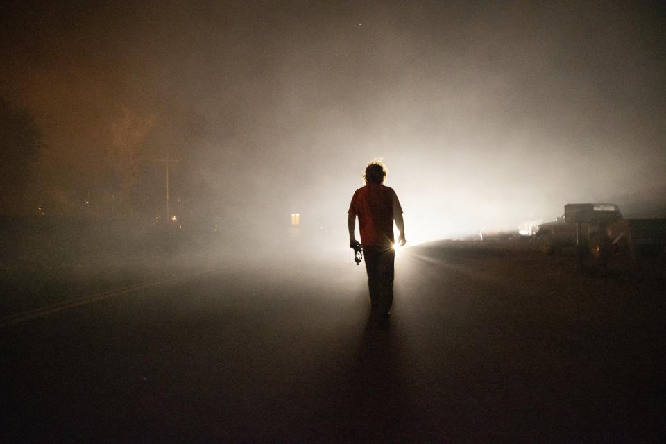 Tom Smith walks on Platina Road after refusing to evacuate from the Zogg Fire near Ono, Calif., on Sunday, Sep. 27, 2020. (AP Photo/Ethan Swope)