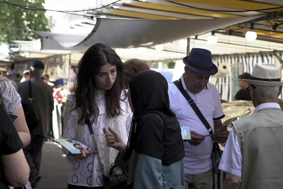 Shannon Seban, a legislative election candidate for the camp of President Emmanuel Macron, campaigns, in the Paris suburb of Ivry-sur-Seine, Tuesday June 25, 2024. Antisemitism has surged as a hot-button issue in France's high-stakes legislative election campaign. On the outskirts of Paris, a candidate who is Jewish is feeling the heat of hatred. Campaigning for the camp of President Emmanuel Macron, Shannon Seban is accompanied by bodyguards as she canvasses for votes, because her party is concerned for her safety. (AP Photo/John Leicester)