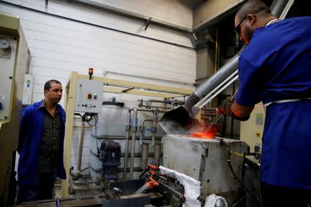 A worker from the Casa da Moeda do Brasil (Brazilian Mint) pours molten metal into a mold to prepare the Rio 2016 Olympic and Paralympic medals in Rio de Janeiro, Brazil, June 28, 2016. REUTERS/Sergio Moraes