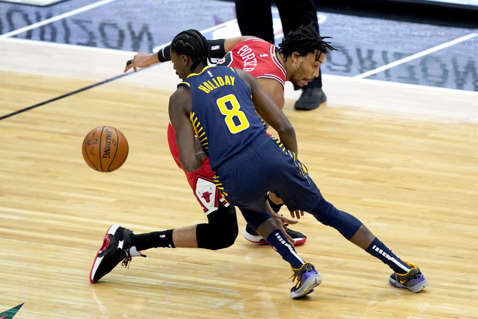 Indiana Pacers' Justin Holiday (8) steals the ball from Chicago Bulls' Otto Porter Jr. during the first half of an NBA basketball game Saturday, Dec. 26, 2020, in Chicago. (AP Photo/Charles Rex Arbogast)