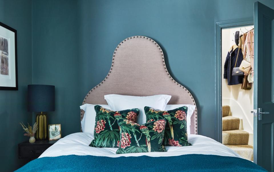 a room with a pink headboard and blue walls