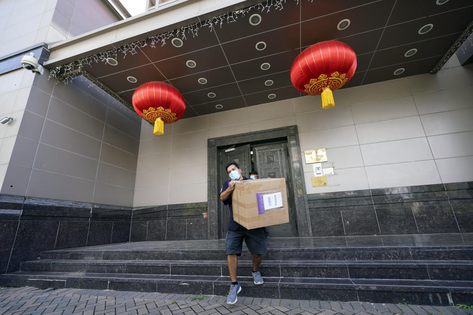 A FedEx employee removes a box from the Chinese Consulate Thursday, July 23, 2020, in Houston. China says “malicious slander" is behind an order by the U.S. government to close its consulate in Houston, and maintains that its officials have never operated outside ordinary diplomatic norms. (AP Photo/David J. Phillip)