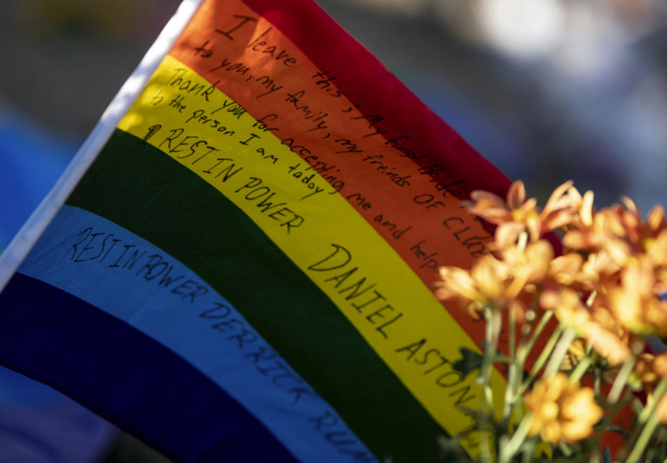 A flag with a message to Daniel Aston and Derrick Rump, victims of the mass shooting at Club Q, sits at a memorial outside the club Monday, Nov. 21, 2022, in Colorado Springs, Colo. (AP Photo/Parker Seibold)