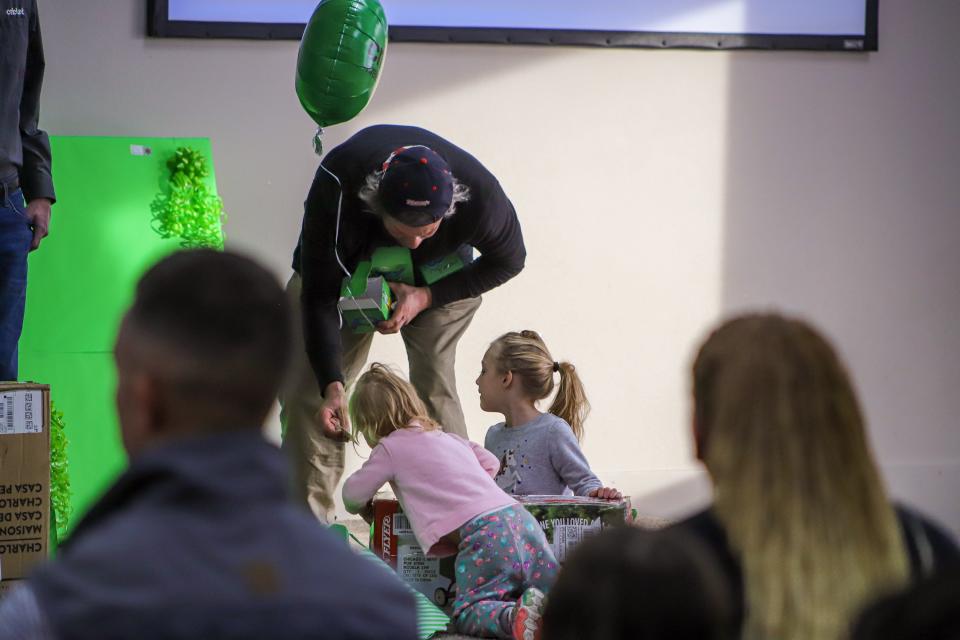 Daniel Baker helps his daughters unwrap gifts at the Boys and Girls Club in Sioux Falls on Tuesday, Nov. 29.