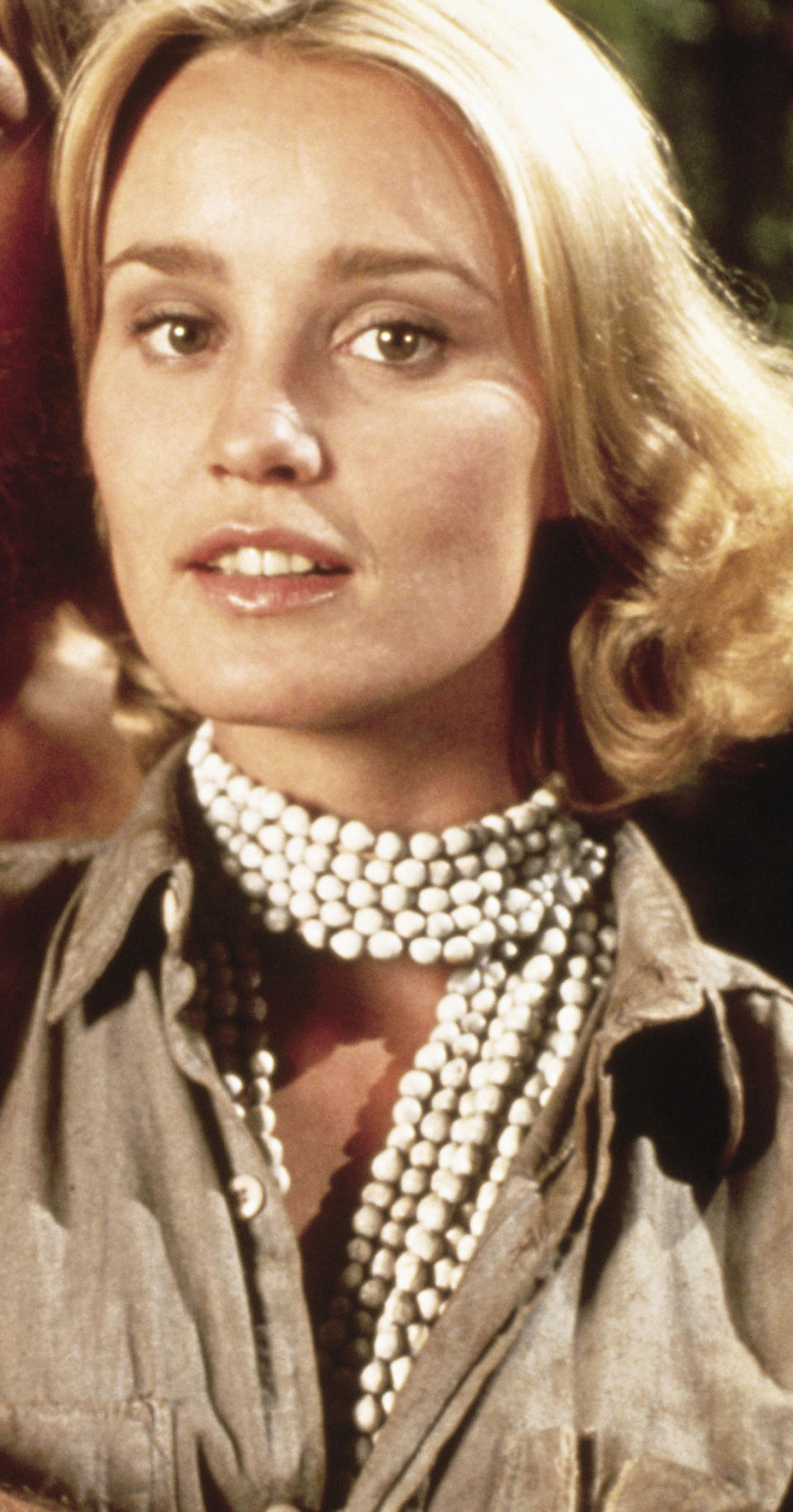 Jessica Lange with short curly hair while wearing long pearls