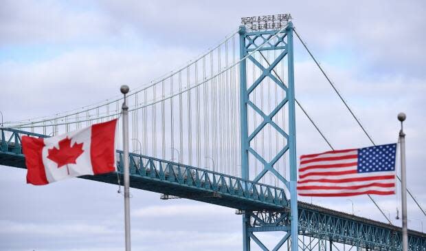 Canadian and American flags fly near the Windsor-Detroit Ambassador Bridge. (Rob Gurdebeke/The Canadian Press - image credit)