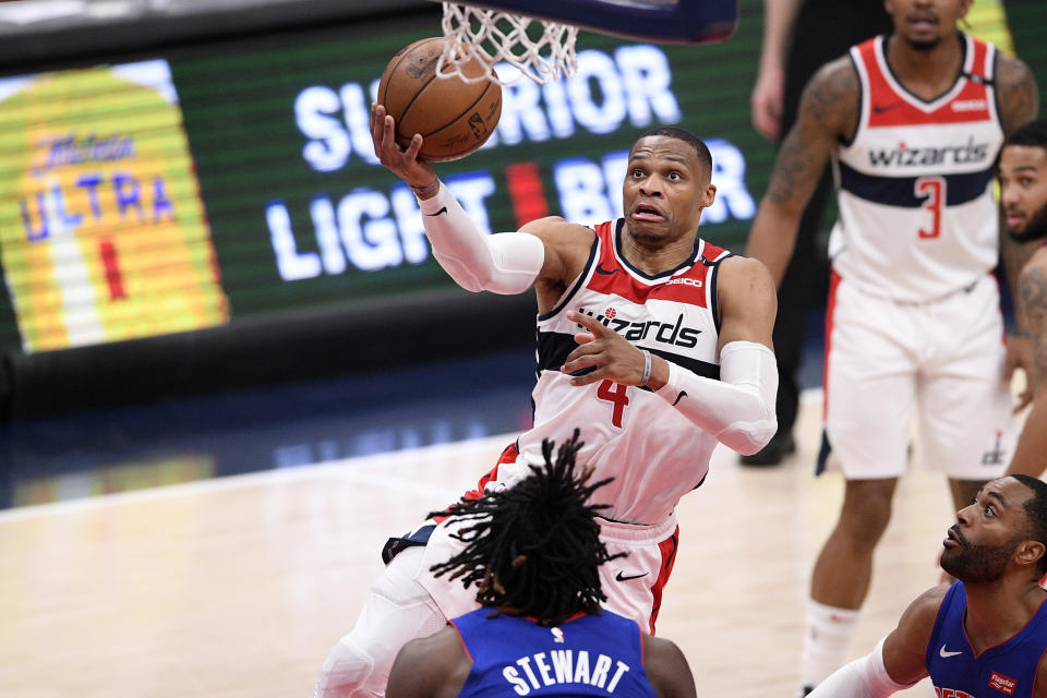 Washington Wizards guard Russell Westbrook (4) goes to the basket against Detroit Pistons center Isaiah Stewart, bottom, during the first half of an NBA basketball game, Saturday, April 17, 2021, in Washington. (AP Photo/Nick Wass)