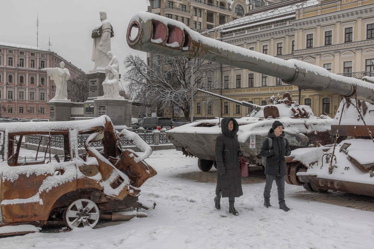 Pedestrians walks past destroyed Russian military vehicles blanketed in snow in front of Saint Michael's Golden-Domed Monastery, in downtown Kyiv (Roman Pilipey/AFP via Getty Images)