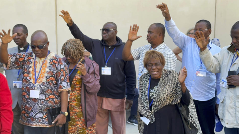 African delegates to the General Conference of the United Methodist Church pray outside the Charlotte Convention Center, in Charlotte, N.C., Thursday, May 2, 2024. They gathered to protest the conference vote that replaced the church's definition of marriage with one that doesn't limit marriage to heterosexual couples. (AP Photo/Peter Smith)