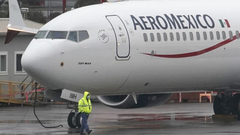 In this Nov. 18, 2020 file photo, a worker wearing a mask walks past a Boeing 737 Max 9 built for Aeromexico as it is prepared for a flight from Renton Municipal Airport, in Renton, Washington.
