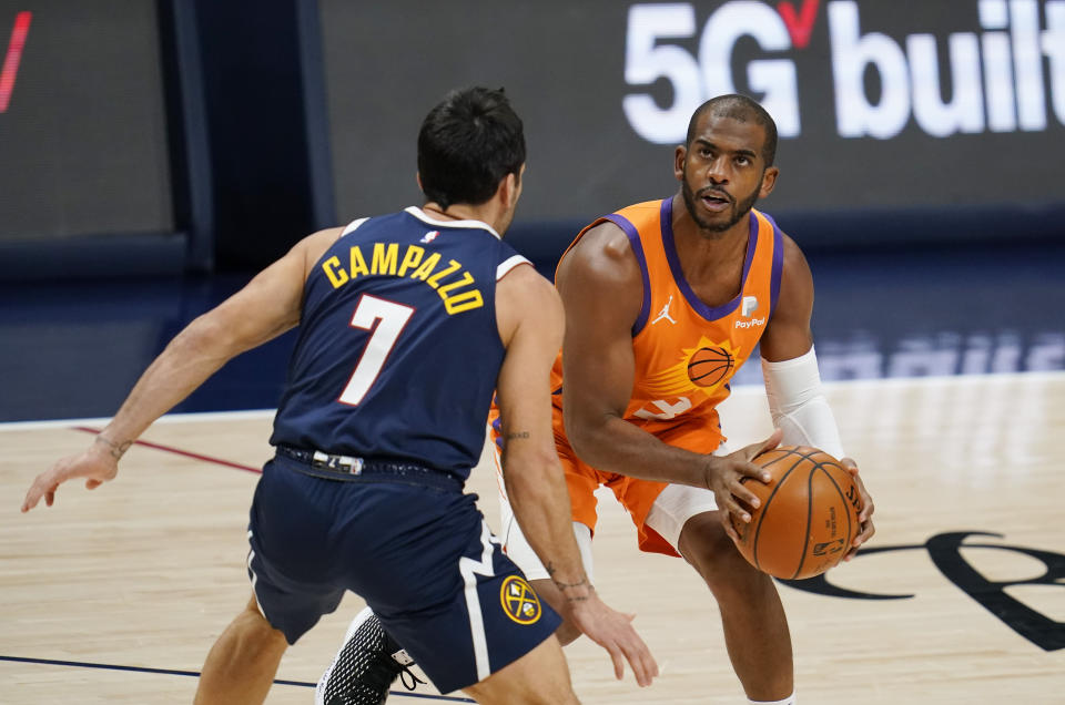 Phoenix Suns guard Chris Paul, right, looks for a shot over Denver Nuggets guard Facundo Campazzo during the first half of an NBA basketball game Friday, Jan. 1, 2021, in Denver. (AP Photo/David Zalubowski)