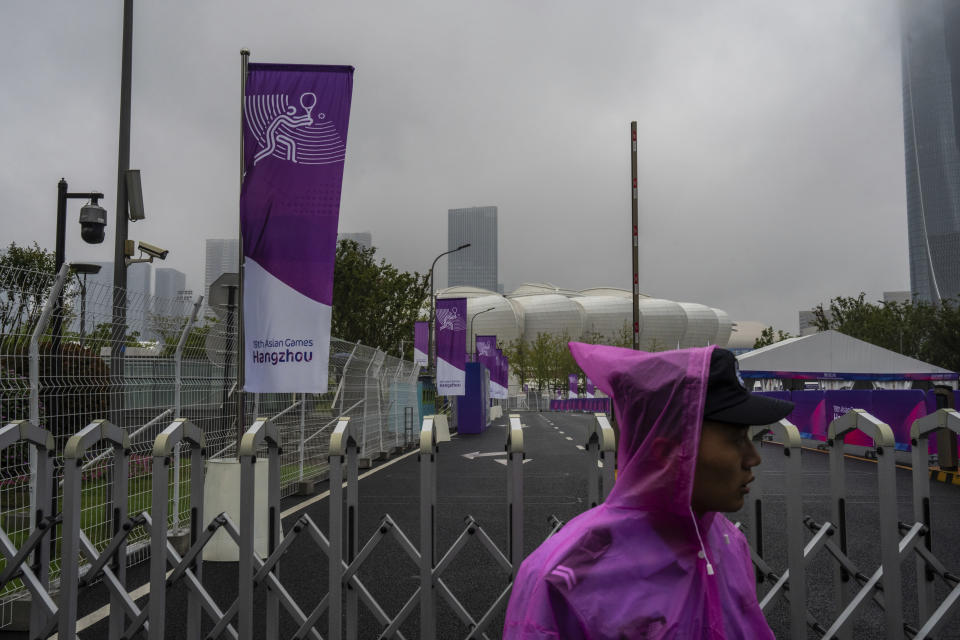 Security staff stands near the Hangzhou Olympic Sports Center Stadium ahead of the 19th Asian Games in Hangzhou, China, Friday, Sept. 21, 2023. (AP Photo/Louise Delmotte)