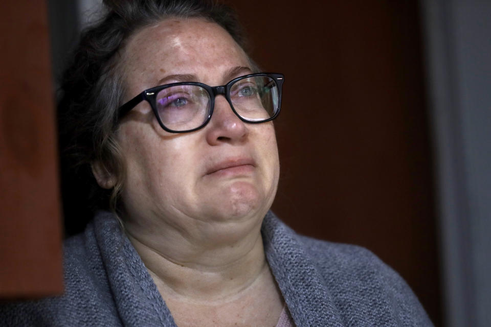 Susan Kenney, of Ware, Mass., who lost her father to the coronavirus, is tearful while speaking to a reporter from The Associated Press on the front porch of her home, Thursday, April 30, 2020, in Ware. Her father, Air Force veteran Charles Lowell, was a resident at the state-run Holyoke Soldiers' Home. While the death toll at the state-run Holyoke Soldiers' Home continues to climb, federal officials are investigating whether residents were denied proper medical care and the state's top prosecutor is deciding whether to bring legal action. (AP Photo/Steven Senne)