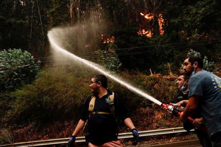 Un bombero trabaja mientras un incendio forestal quema la zona forestal en Tomé, Chile, 3 de febrero de 2023